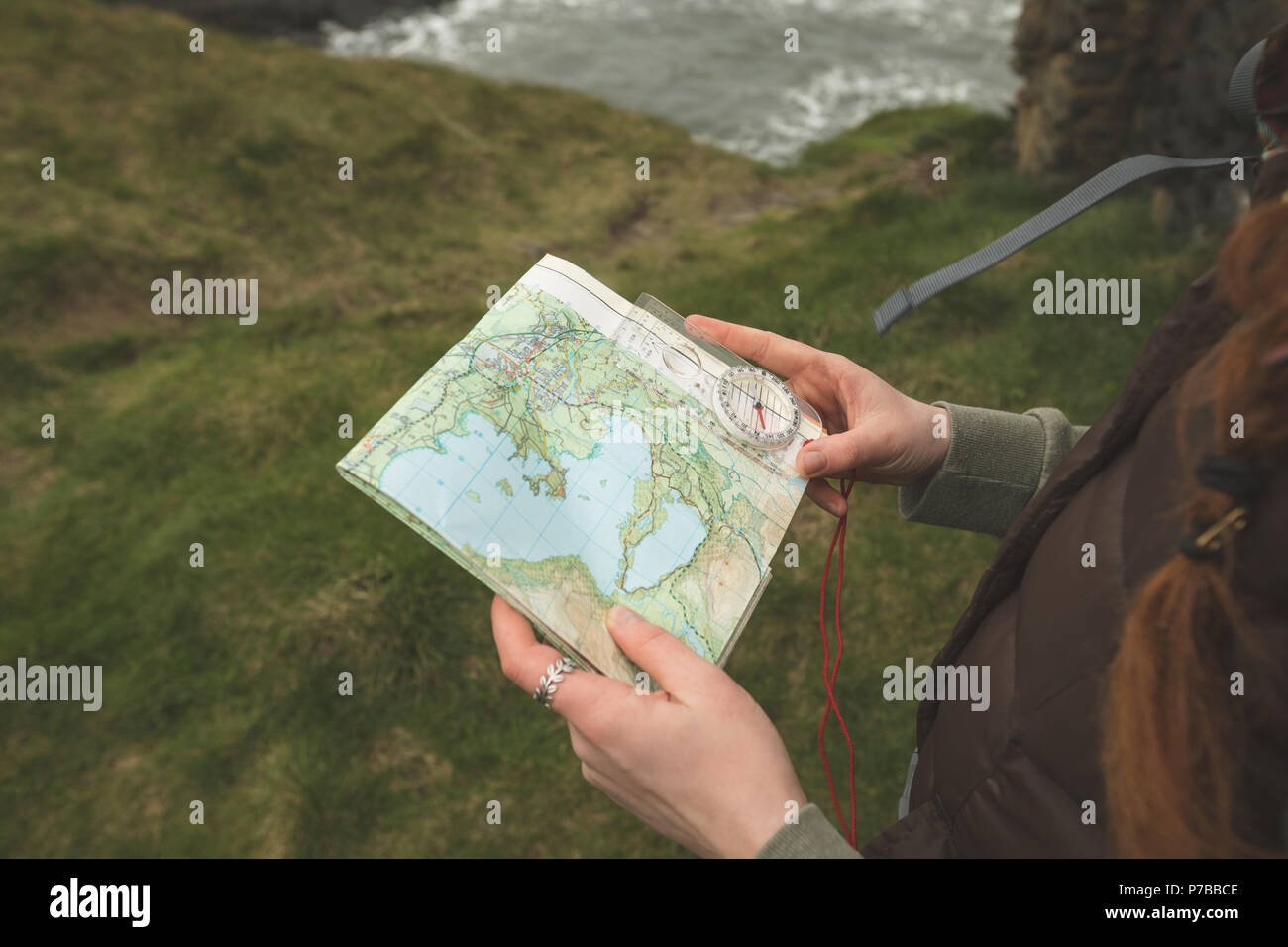 Female hiker reading a map à la côte de la mer Banque D'Images