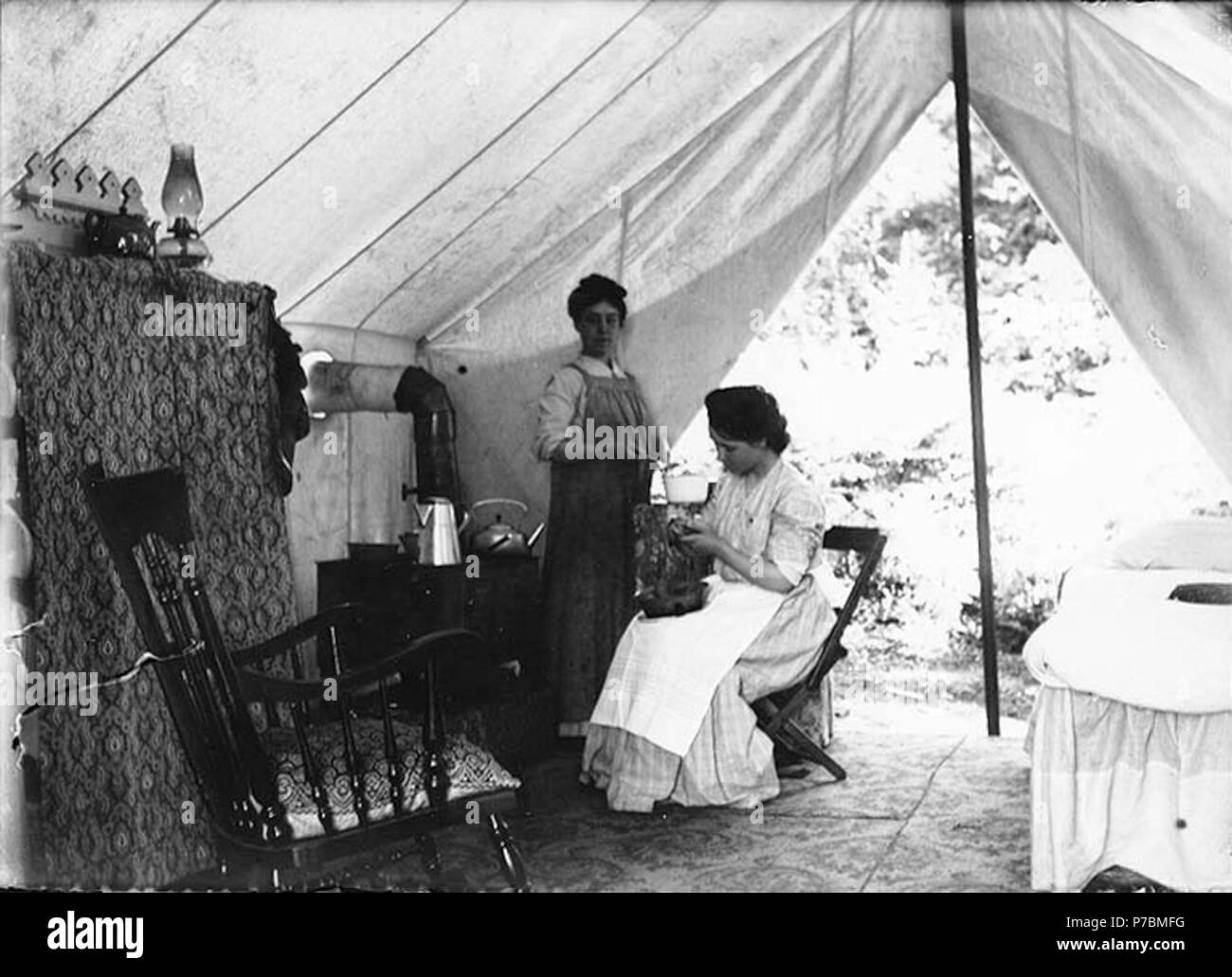 . Anglais : deux femmes dans la cuisine de l'intérieur de tente meublée avec cuisinière et chaises, Burton, Washington, Vashon Island, ca. 1905 . Anglais : Sur le manchon de négatif : la cuisson en tente dans Burton Sujets (LCTGM) :--Washington (État)--Burton ; Camping--Washington (État)--Burton ; les femmes--Washington (État)--Burton ; Côté Cuisine--Washington (État)--Burton, d'ustensiles de cuisine . vers 1905 81 deux femmes dans la cuisine de l'intérieur de tente meublée avec cuisinière et chaises, Burton, Washington, Vashon Island, ca 1905 (266 bar) Banque D'Images