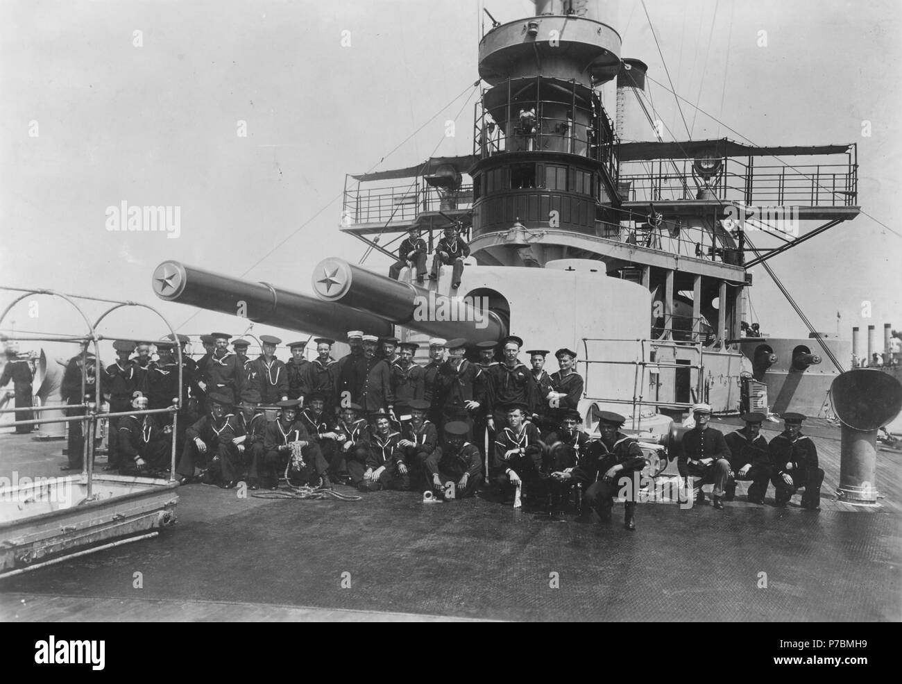 . USS Iowa. (Anglais : Battleship n° 4) marins et soldats de l'équipage du navire posé devant elle de l'avant 12/35 tourelle à canon, vers août 1898. Photographié par William H. Rau. Notez que l'Iowa a été partiellement repeints de gris en temps de guerre. Notez aussi la cloche du navire au-dessous de la timonerie. Croiseur cuirassé USS Brooklyn (n° 3) est dans la bonne distance. vers août 1898 81 USS Iowa - NH 87 Banque D'Images