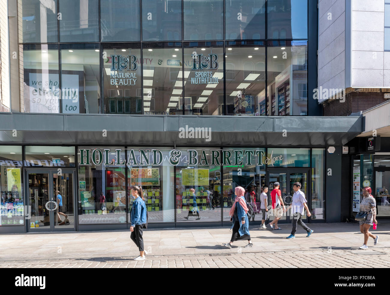 Les gens en passant devant une succursale de la Hollande et Barrett dans le centre de Manchester, Royaume-Uni Banque D'Images