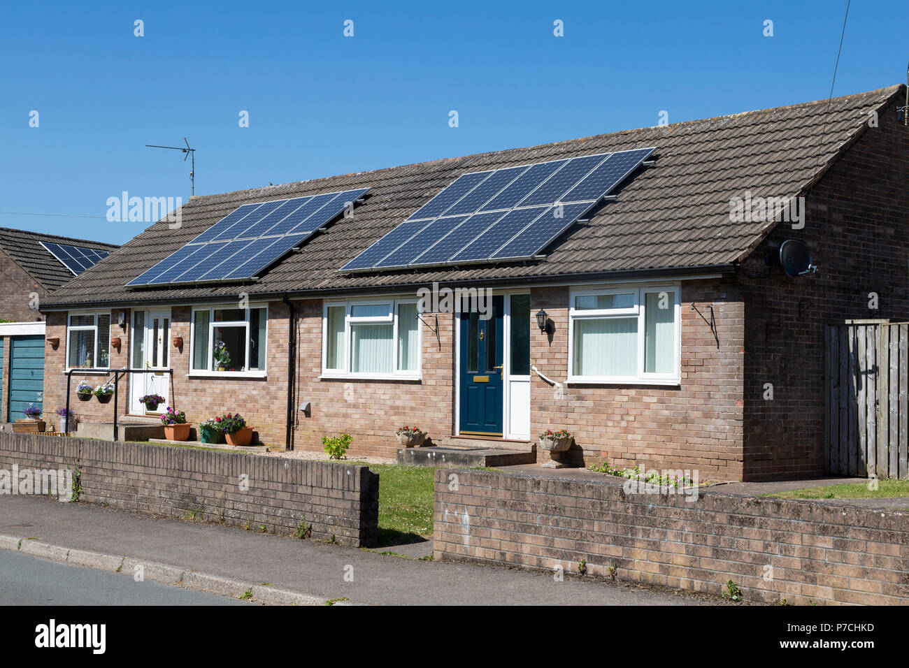 Une paire de petits bungalows équipés de panneaux solaires, sur une journée ensoleillée. Banque D'Images