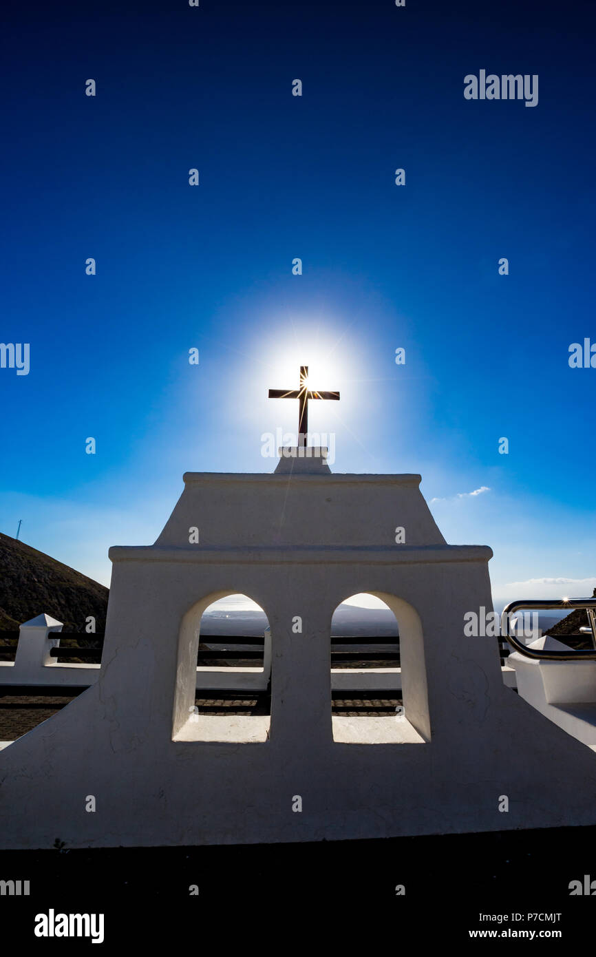 Soleil chaud provenant de la célèbre croix chrétienne à l'endroit appelé Mirador de Puerto del Carmen à Lanzarote, îles Canaries, Espagne. Deux fenêtres blanches et bleu clair fond de ciel de printemps Banque D'Images