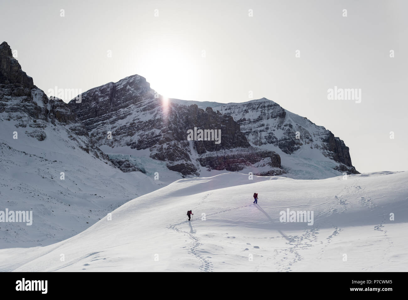 Couple en train de marcher sur une montagne de neige Banque D'Images
