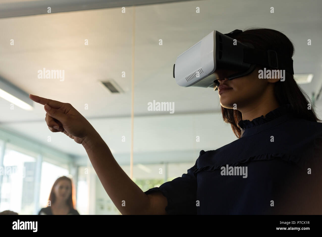Female executive en utilisant casque de réalité virtuelle Banque D'Images