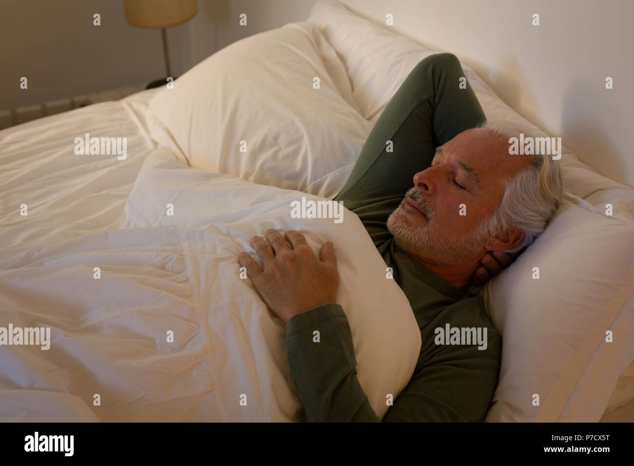 Senior man sleeping in bedroom Banque D'Images