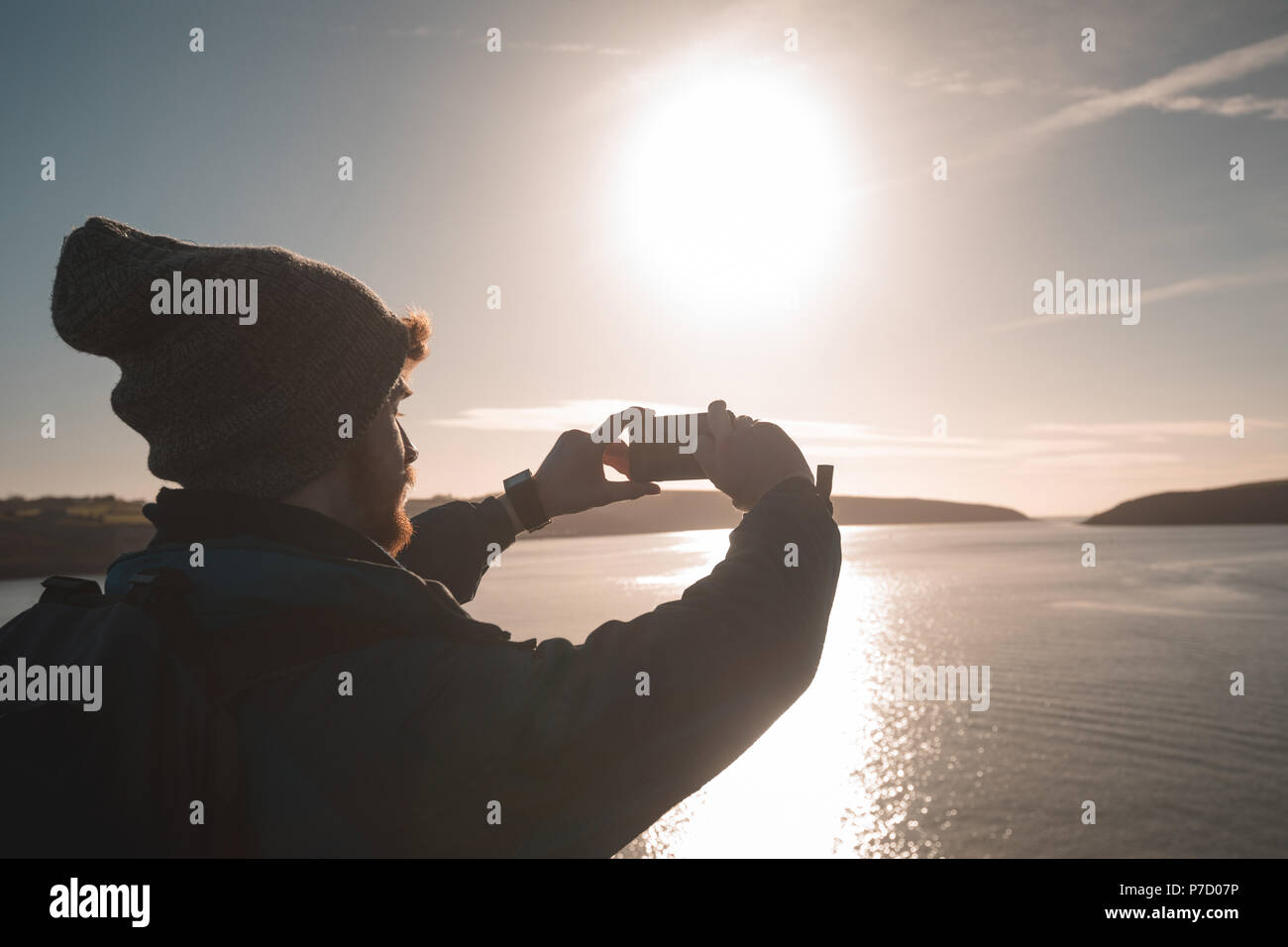 Male hiker taking photo avec téléphone mobile près du lac Banque D'Images