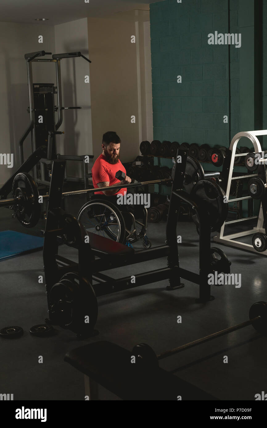 Homme handicapé en fauteuil roulant sur l'élaboration avec haltère Banque D'Images