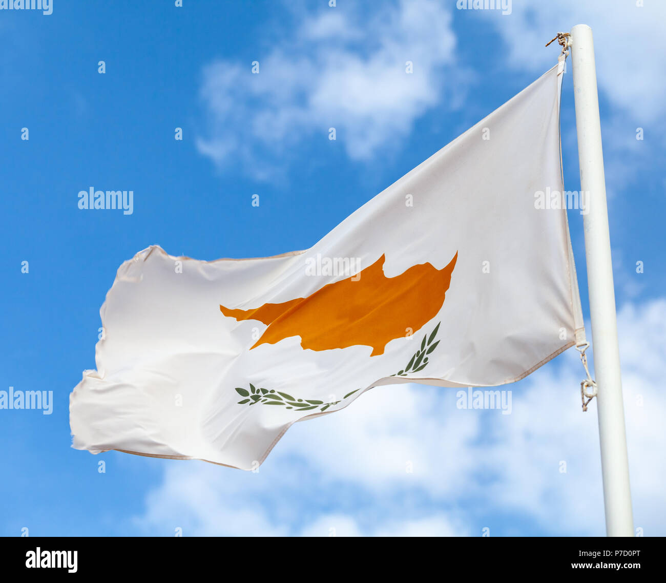 Brandissant le drapeau national de Chypre sur le vent sur nuageux ciel bleu Banque D'Images