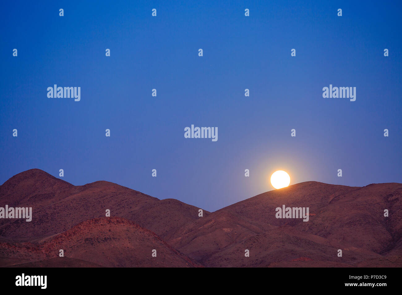 Lever de soleil sur les montagnes, la pleine lune, Purros, région de Kunene, Namibie Banque D'Images