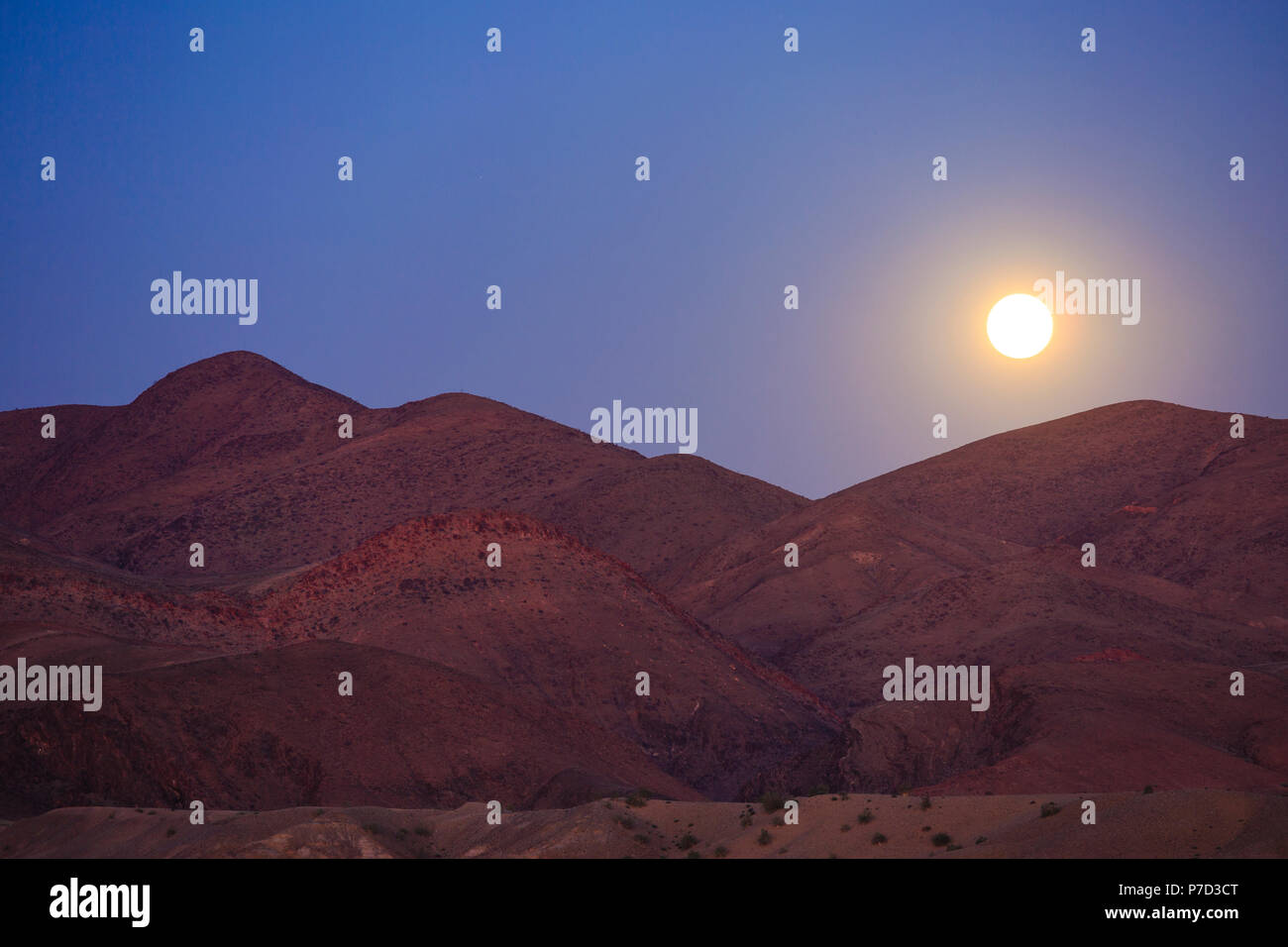 Lever de soleil sur les montagnes, la pleine lune, Purros, région de Kunene, Namibie Banque D'Images