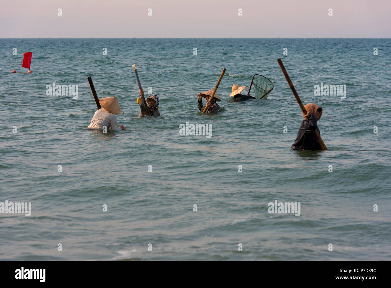 Les chasseurs, les pêcheurs de moules coquillages portant des chapeaux de paille, la plage Cua Dai à Hoi An, Vietnam Banque D'Images