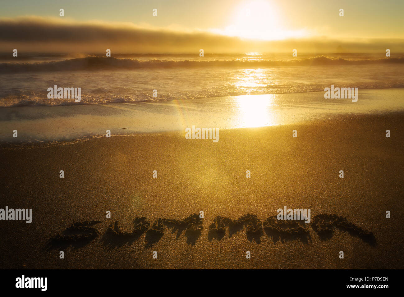 Coucher de soleil sur l'océan et sur la plage l'été avec le mot écrit dans le sable. Concept de la saison. Banque D'Images
