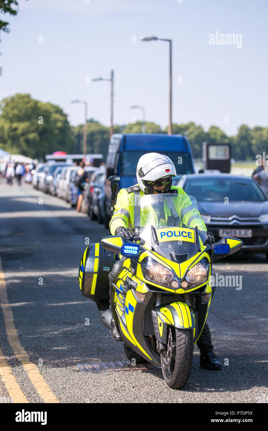 Motocycliste police en uniforme assis sur moto garée en attente, dans une route secondaire, à l'escorte de la princesse Anne's véhicule à travers les rues de Worcester. Banque D'Images