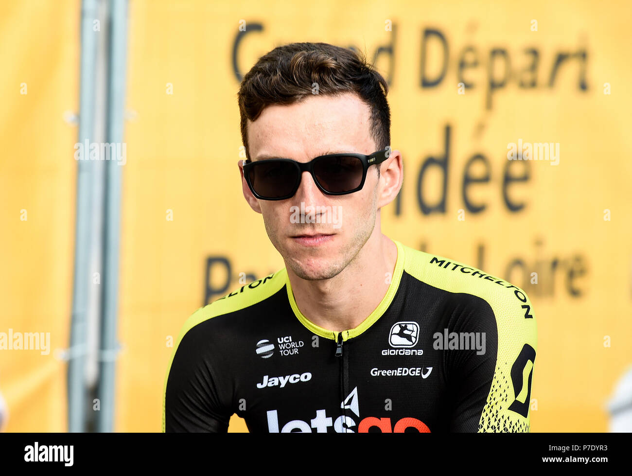 Adam Yates s'assoit et attend avant de monter sur le podium. Lors des présentations de l'équipe à la place Napoléon, la Roche-sur-Lyon, France. Banque D'Images