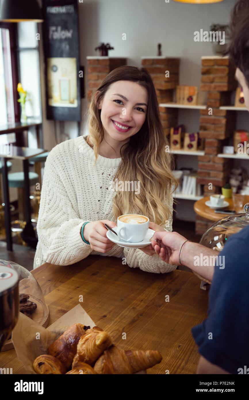 Jeune femme se tasse de café de waiter Banque D'Images