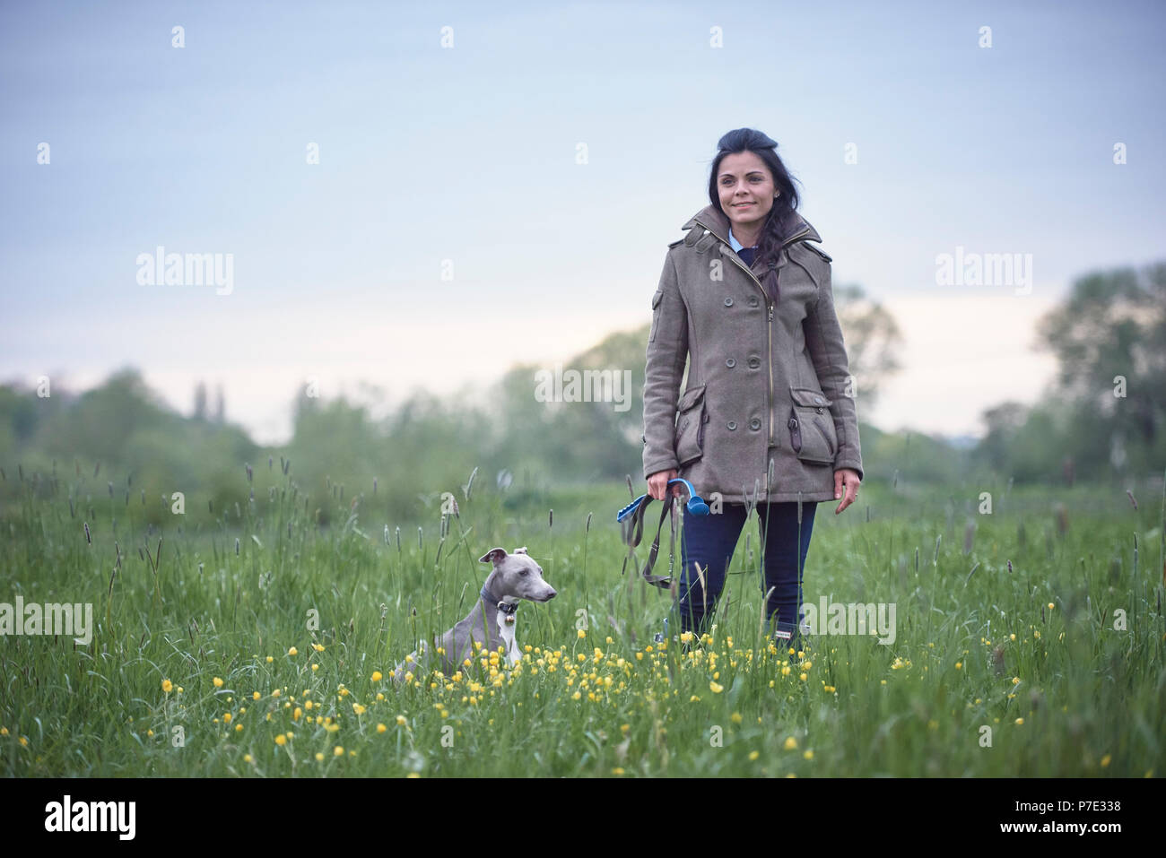 Femme mature avec son chien dans le champ, portrait Banque D'Images