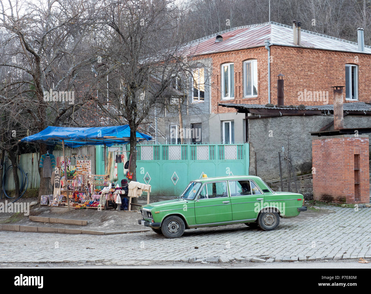 Sighnaghi, Géorgie - 4 décembre 2017 : vieille voiture taxi russe et blocage de souvenirs en face de Saint Nino monastère à Bodbe Banque D'Images