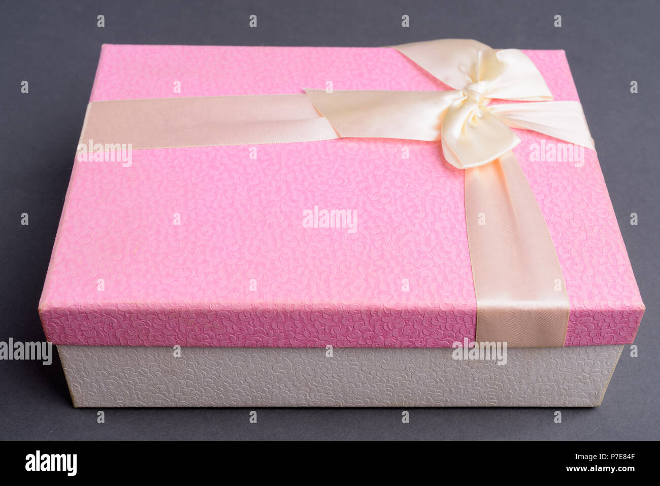 Boîte cadeau rose contre l'arrière-plan gris Banque D'Images