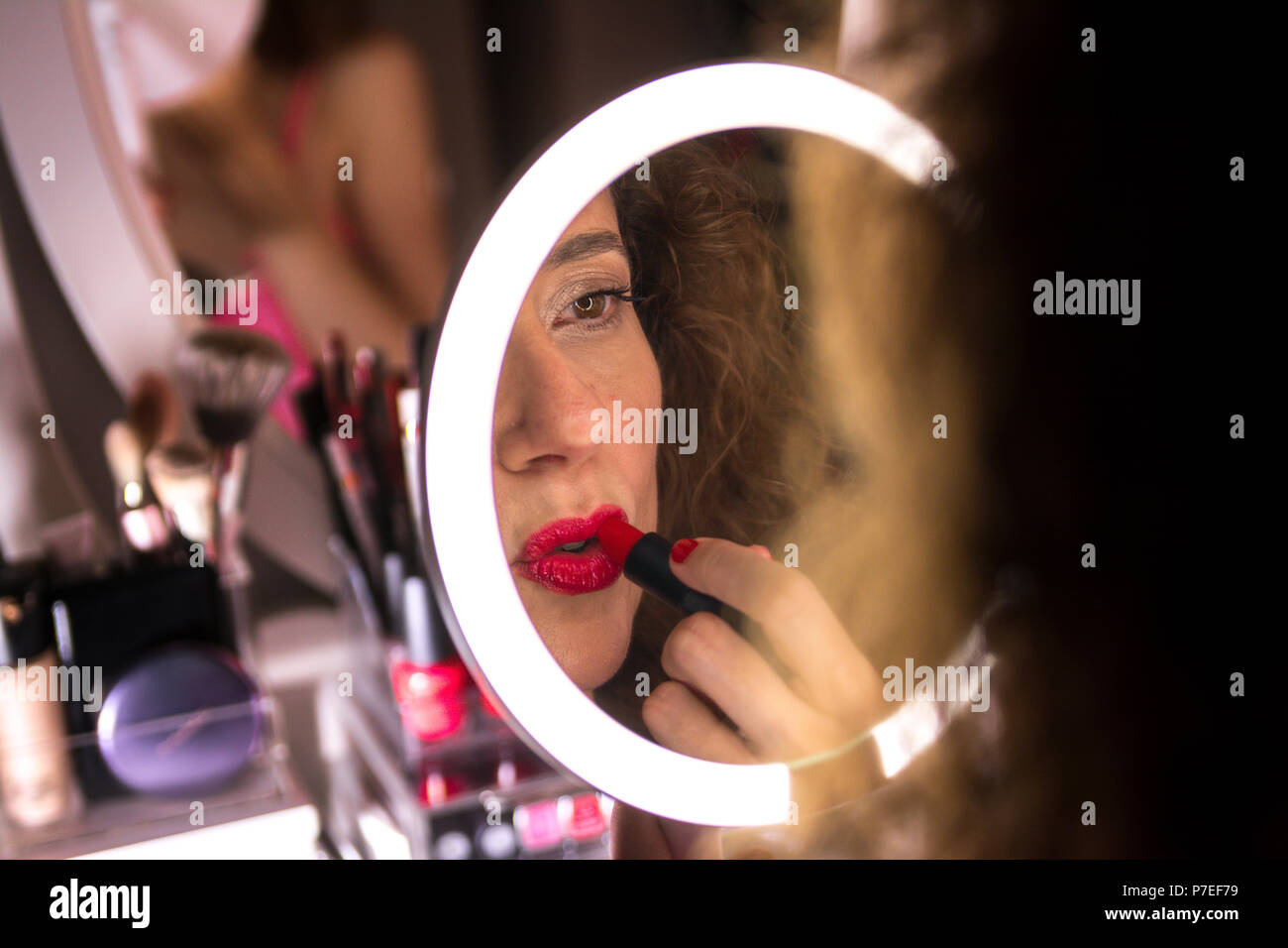 Brunette woman applying make, de porter le rouge à lèvres. Se concentrer sur sa réflexion Banque D'Images
