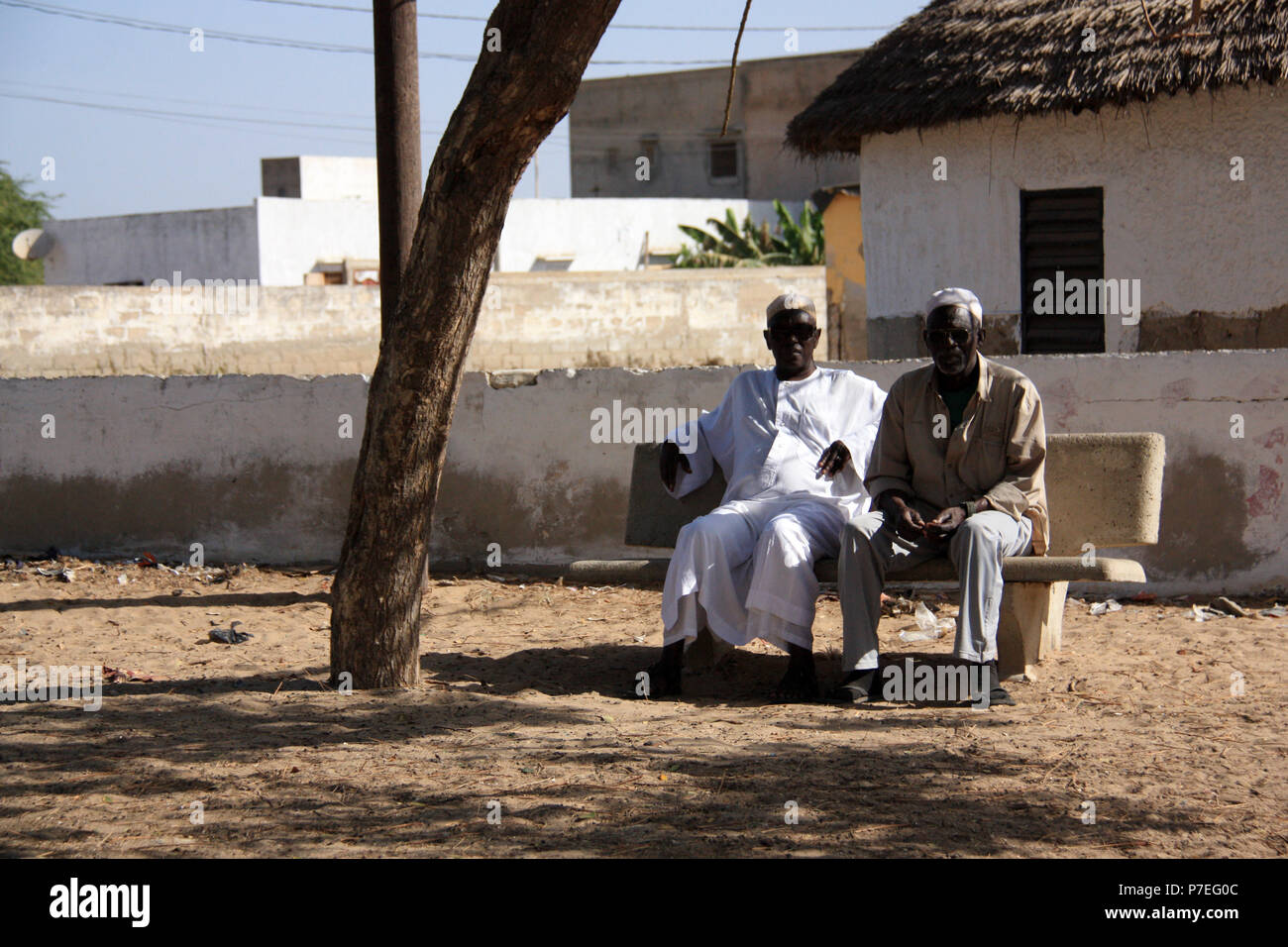Deux vieillards assis sur un banc à côté de la route près de Saint-Louis-du-Sénégal, Sénégal Banque D'Images