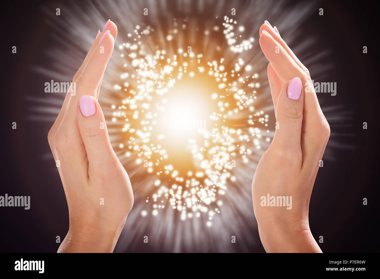 Close-up of a Woman's Hand Holding Light Against Colorful Background Banque D'Images
