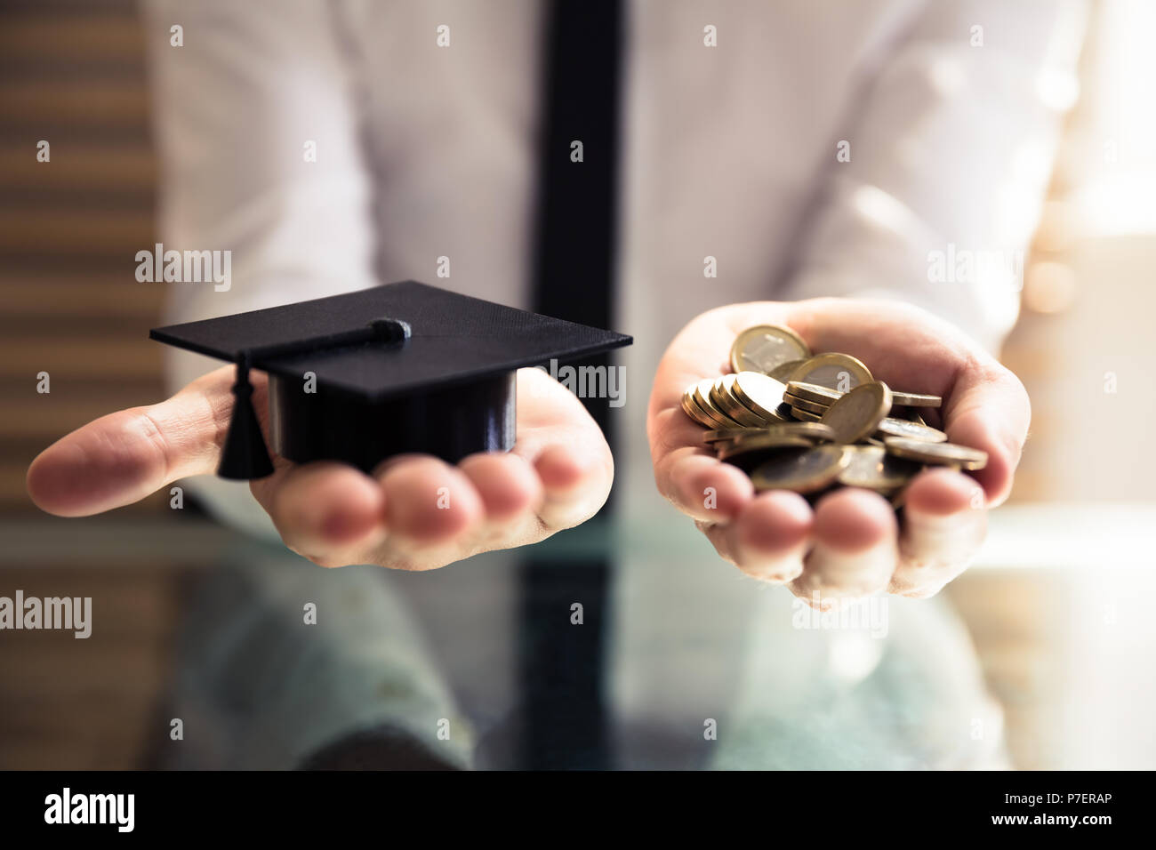 Human Hand Holding Graduation Hat noir et pièces d'Or plus de 24 Banque D'Images
