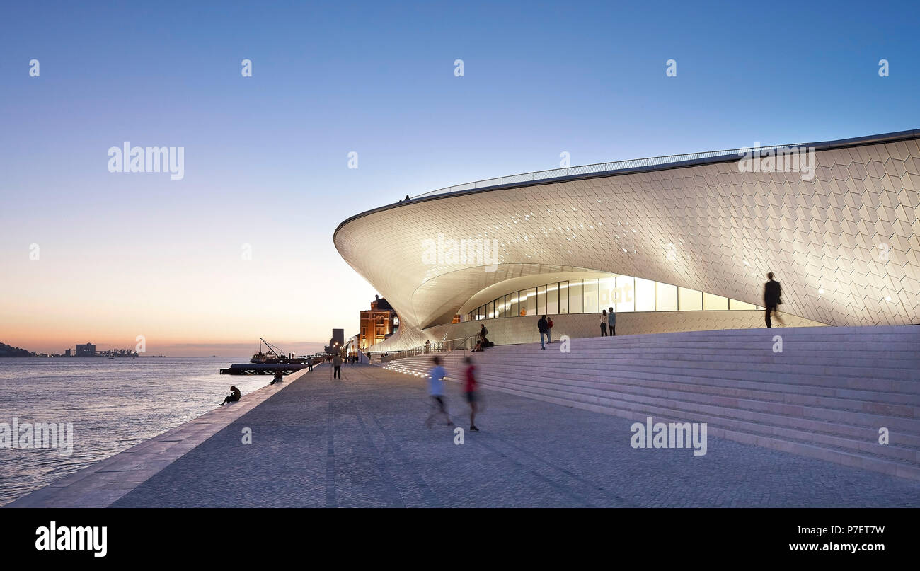 Façade éclairée en lumière du soir. MAAT, Lisbonne, Portugal. Architecte : UN LA, 2016. Banque D'Images