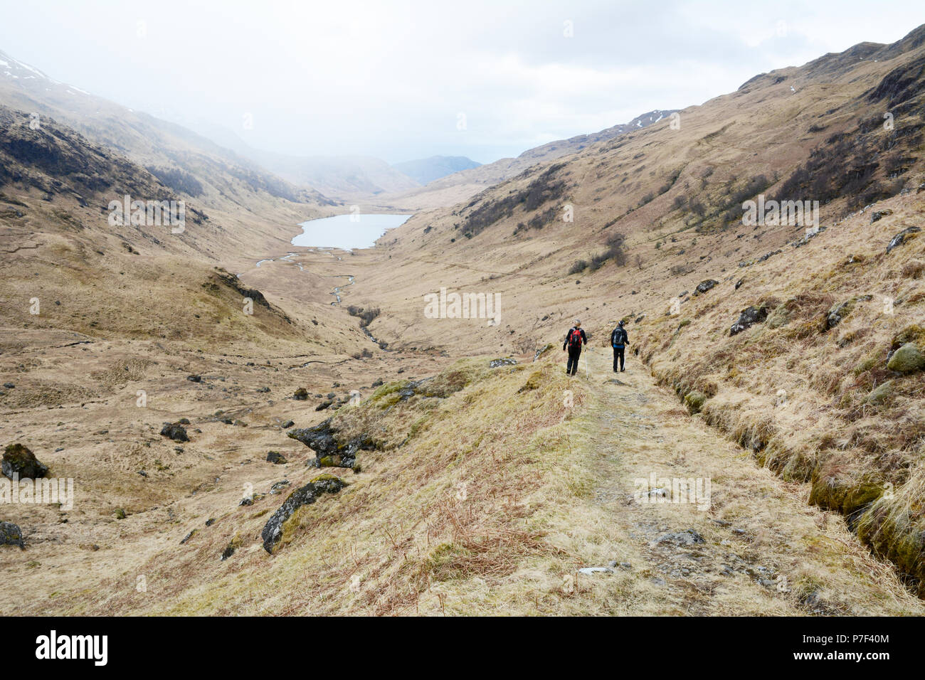 Deux Randonneurs marchant dans un sentier de la vallée d'un munro dans les Highlands écossais, Knoydart Peninsula, nord-ouest de l'Ecosse, Grande-Bretagne. Banque D'Images