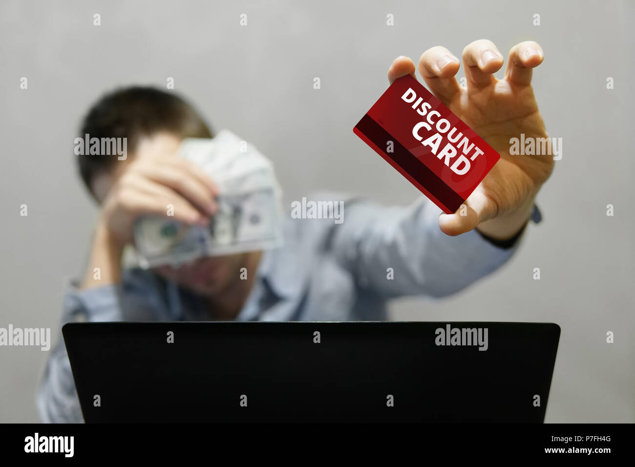 Magasinage en ligne et de paiement. Bel homme montrant une carte de crédit et à l'aide de navigation portable internet. Young businessman holding une carte de réduction et la Banque D'Images