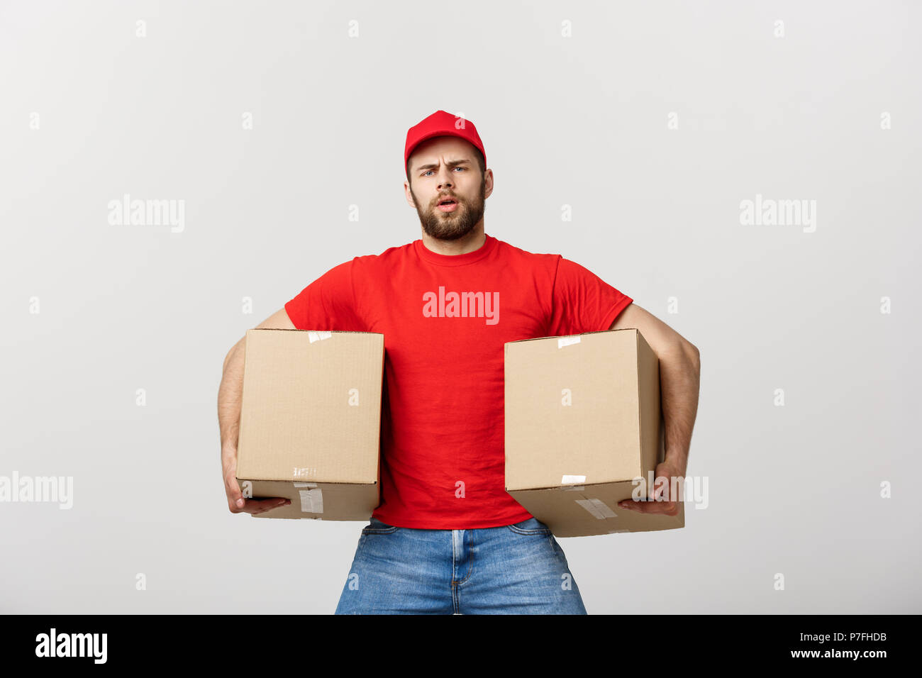 Épuisé handsome man holding boxes et prendre une pause. Isolated on white Banque D'Images