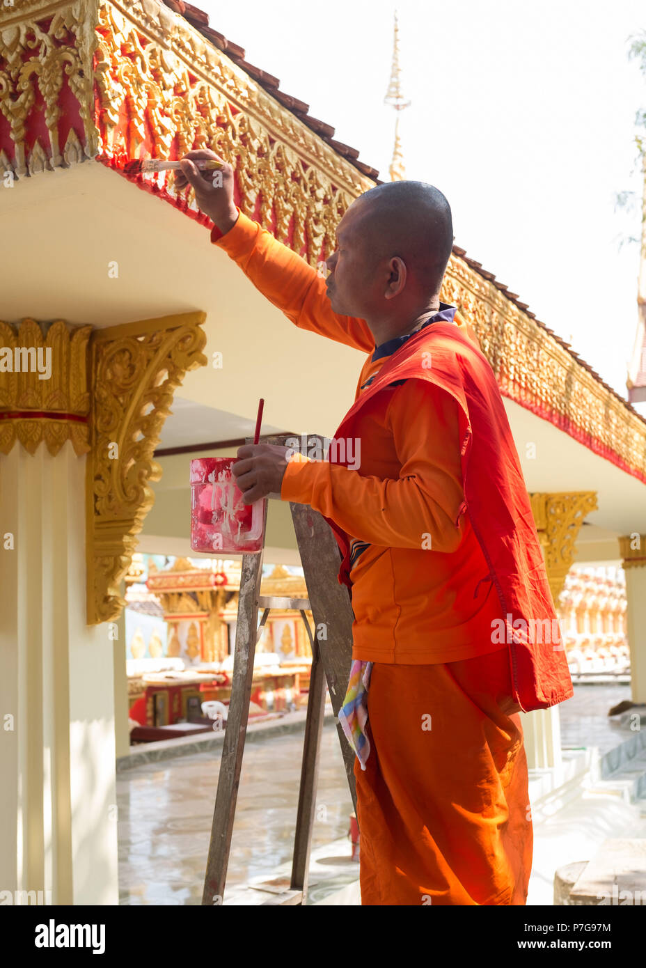 Le moine bouddhiste debout sur l'échelle et la peinture temple, Vientiane, Laos, Asie. Banque D'Images