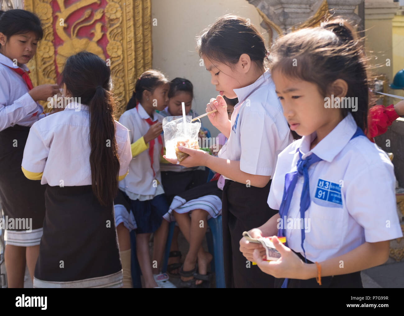 Les élèves manger pendant la pause déjeuner, Vientiane, Laos, Asie. Banque D'Images