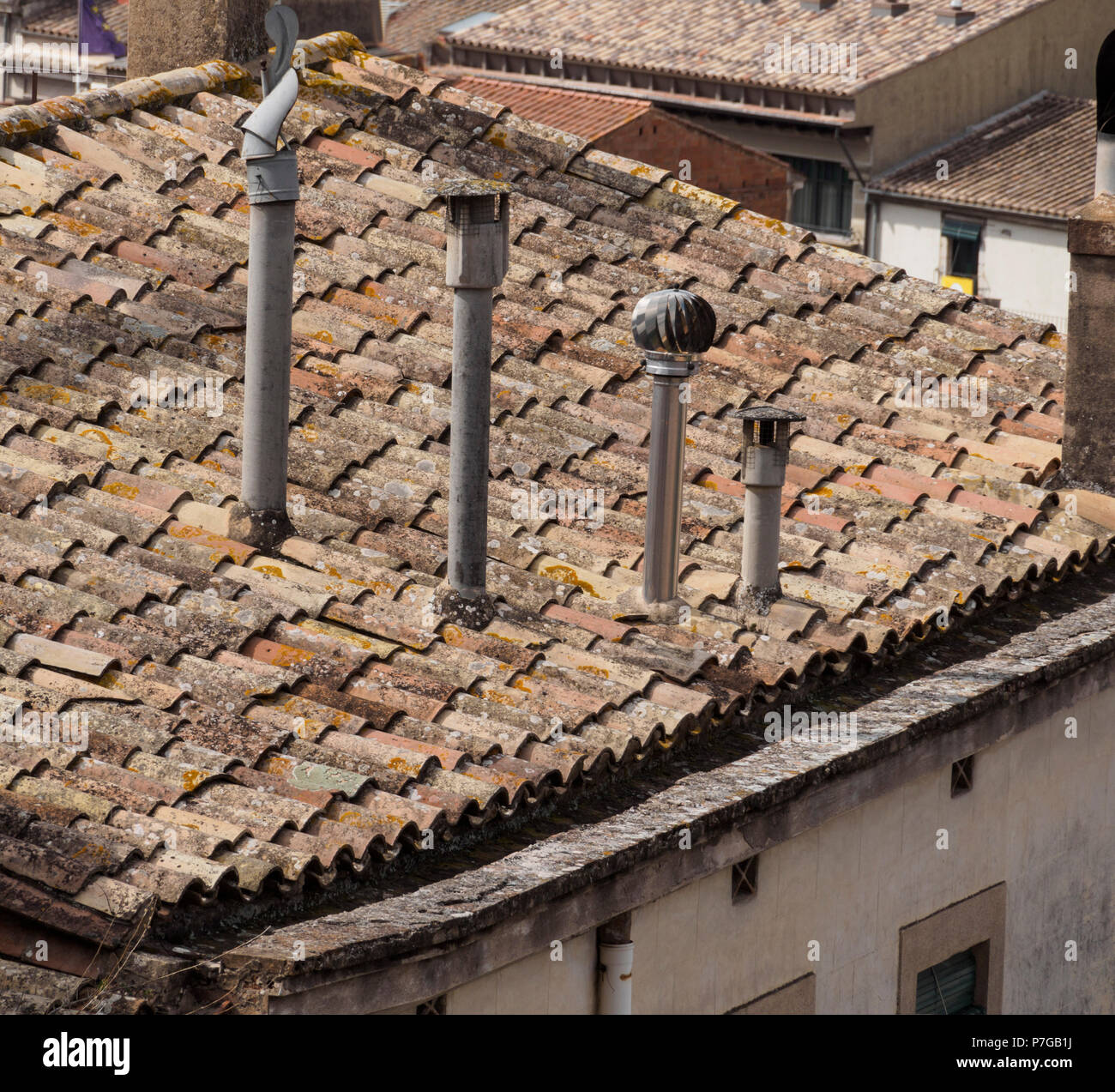 Gérone, Catalogne, région du nord de l'Espagne - cheminées sur un vieux toit avec pantiled (capots des cuisines ci-dessous). Banque D'Images