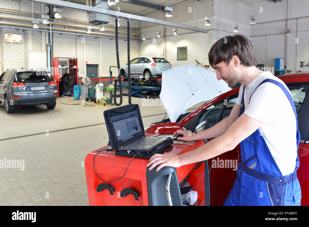 Les réparations mécaniques d'une voiture à moteur avec l'aide d'un ordinateur de diagnostic Banque D'Images Les réparations mécaniques d'une voiture à moteur avec l'aide d'un ordinateur de diagnostic Banque D'Images
