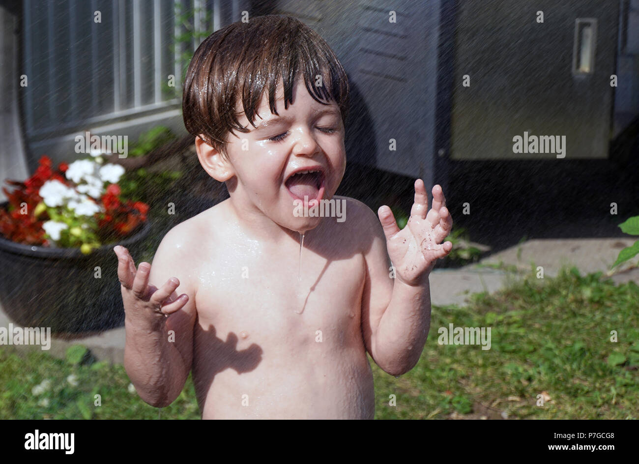 Montréal, Canada, le 2 juillet 2018.jeune garçon de trois d'être aspergé d'eau pendant une vague de chaleur.Credit Mario Beauregard/Alamy Live News Banque D'Images