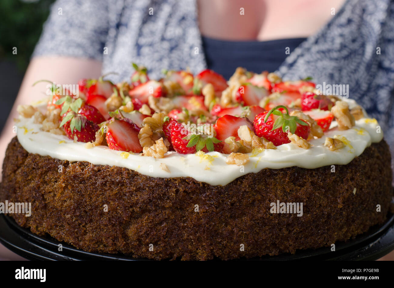 Un carrotcake décoré de fraises fraîches et de noix sur le dessus d'un glaçage de fromage à la crème, le sucre et le citron. Banque D'Images Un carrotcake décoré de fraises fraîches et de noix sur le dessus d'un glaçage de fromage à la crème, le sucre et le citron. Banque D'Images