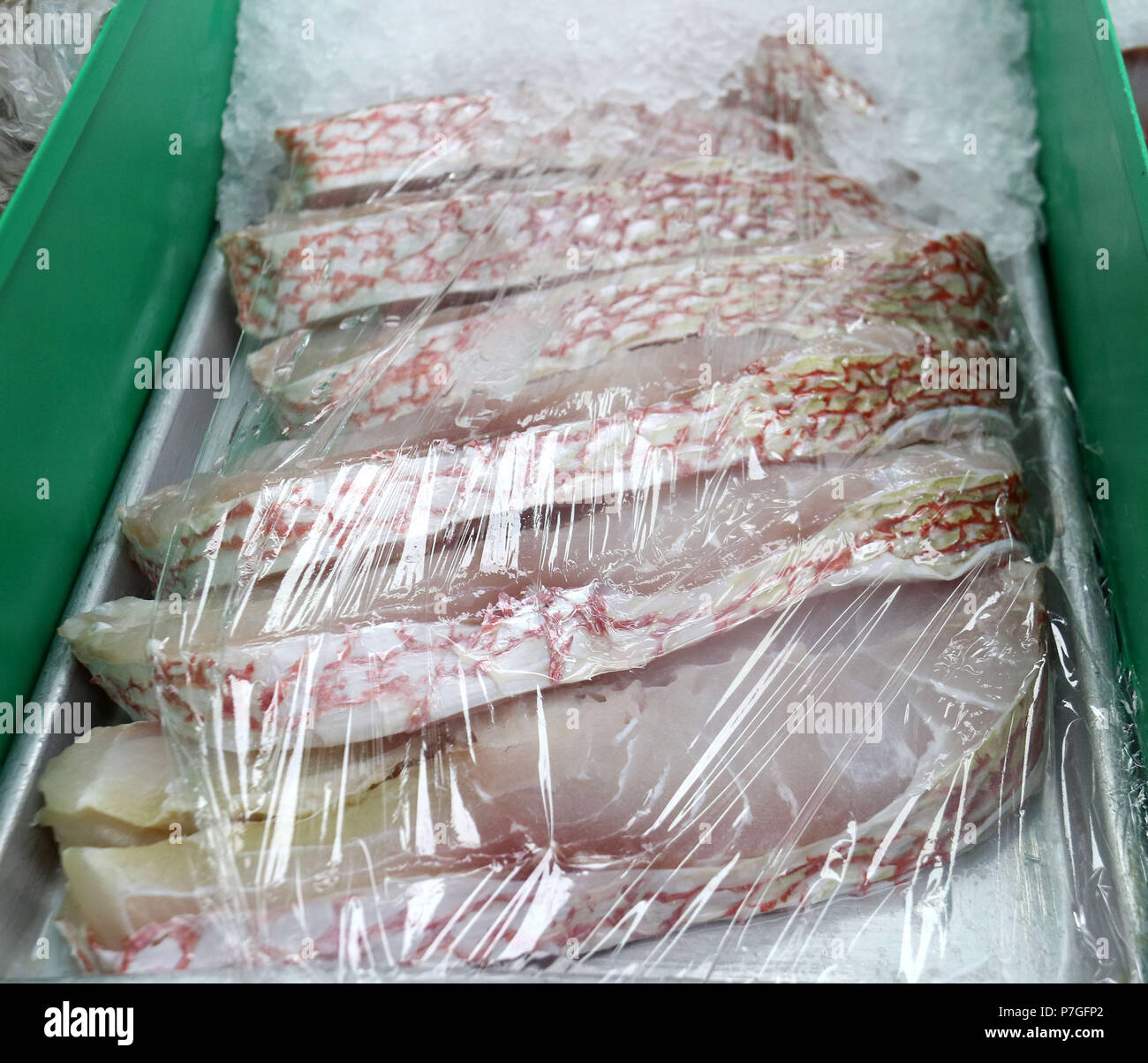 Steaks de vivaneaux rouges enveloppées dans du cellophane sur glace au marché de poissons Banque D'Images
