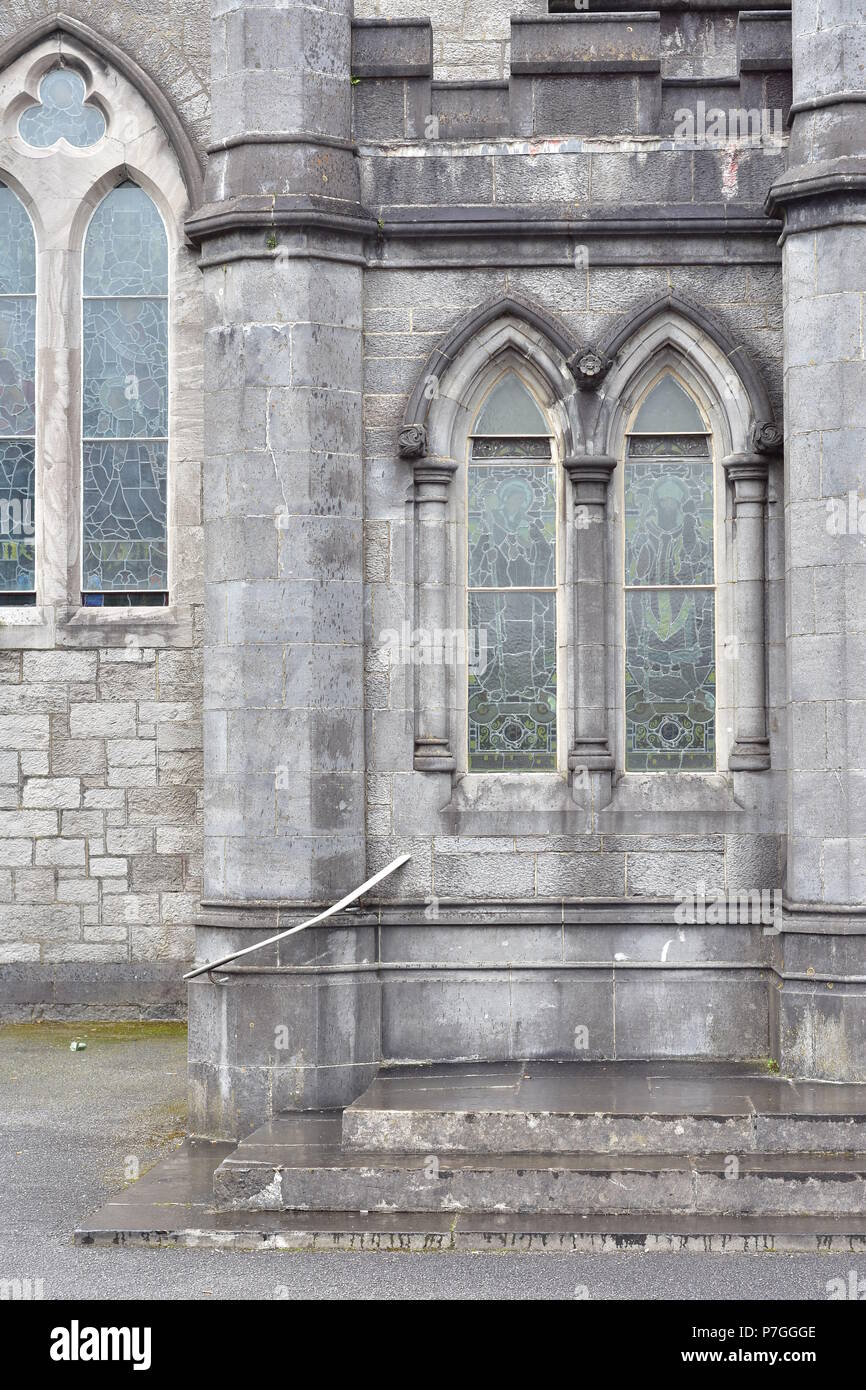 Des fenêtres avec des vitraux de l'église de style anglais ancien en pierre en Irlande. Banque D'Images