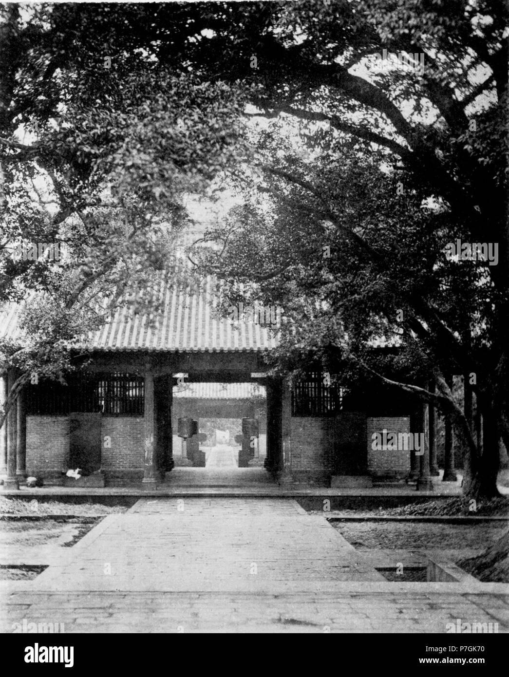 中文（繁體）‎ 清朝時期的廣東省城（廣州 :）河南海幢寺。 Français : John Thomson : HONAM TEMPLE, l'un des plus grands établissements bouddhistes dans le sud de la Chine, se dresse sur la rive sud de la rivière des Perles à Canton. Passer le long de la large chaussée en granit qui effectue à partir de l'eau, et en entrant le porche extérieur, sous l'ombre des arbres vénérables, le visiteur se retrouve au sein d'un vaste compartiment extérieur, ayant des passerelles en face et gigantesque à l'arrière. Deux statues colossales, divinités de la mythologie indienne, et armés et équipés comme des guerriers se présenter à côté de son regard. Ce sont les adoptés guardi Banque D'Images