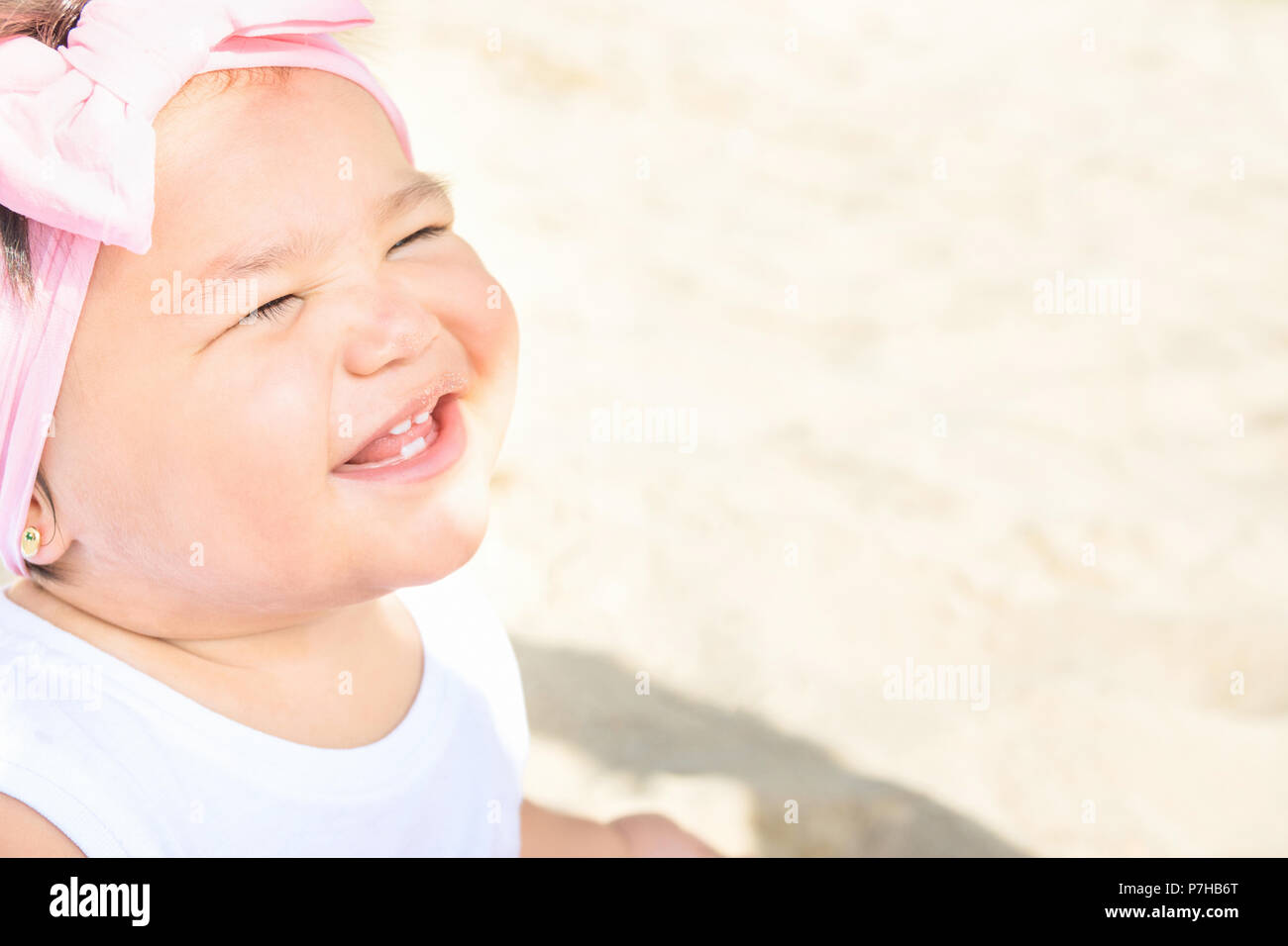 Cute Sweet 1 ans Enfant Bébé fille s'assied sur le sable des plages de l'océan en souriant. Doux visage d'expression. Belle journée ensoleillée. La parentalité, l'enfance Togethernes Banque D'Images