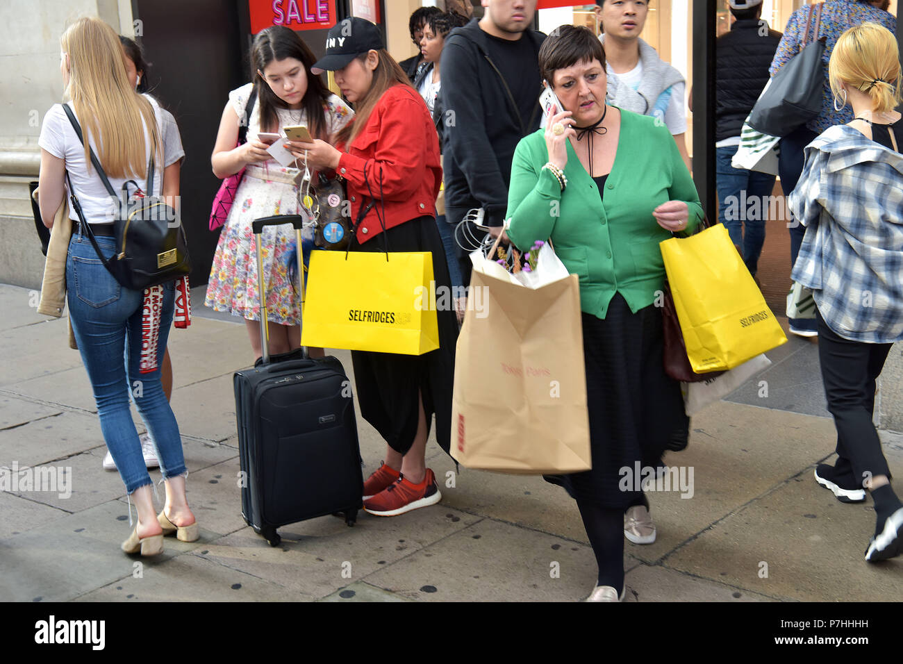 Consommateurs et aux touristes shopping à pied passé le grand magasin Selfridges sur Oxford Street, au centre de Londres. Banque D'Images