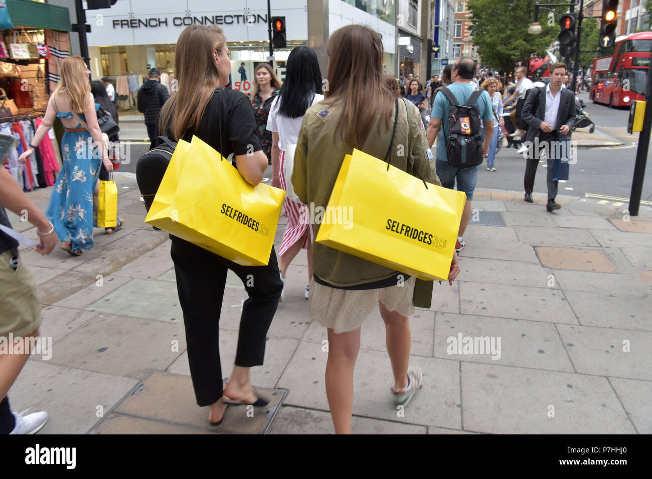 Consommateurs et aux touristes shopping à pied passé le grand magasin Selfridges sur Oxford Street, au centre de Londres. Banque D'Images