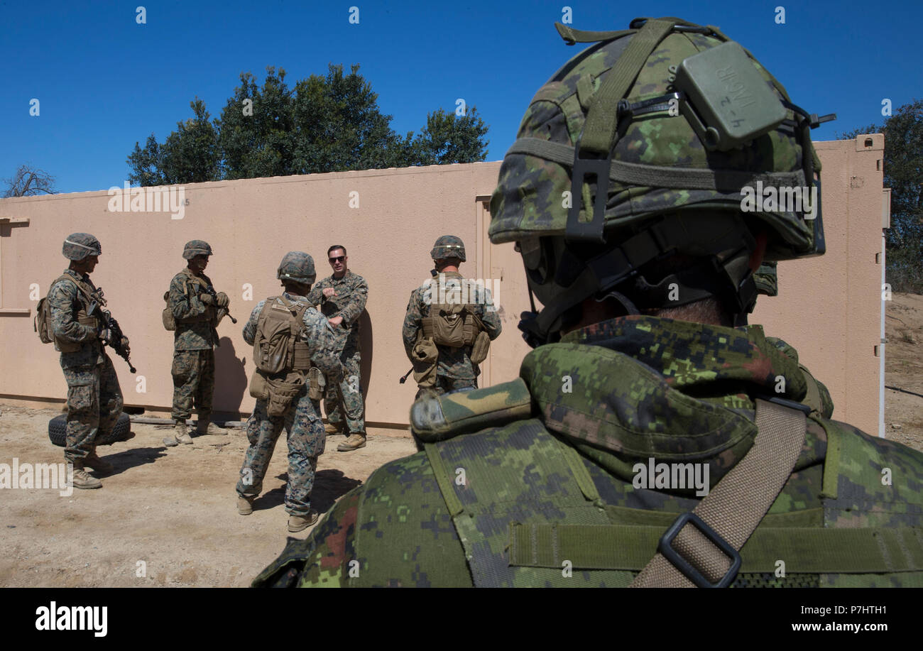 180702-M-PG096-1075 MARINE CORPS BASE CAMP PENDLETON, en Californie (2 juillet 2018) - L'Armée canadienne le TSD. Michel Simard, un carabinier avec le Royal 22e Régiment, observe les Marines des États-Unis avec 2e bataillon du 1er Régiment de Marines, au cours d'un combat-ville percer dans le cadre du Rim of the Pacific (RIMPAC) au Marine Corps Base Camp Pendleton, en Californie, le 2 juillet 2018. RIMPAC démontre la valeur des forces amphibies et fournit la formation de grande valeur pour la tâche hautement organisée, capable de travail air-sol marin l'amélioration de la capacité d'intervention de crise critique de Marines américains dans le Pacifique. Vingt-cinq nat Banque D'Images