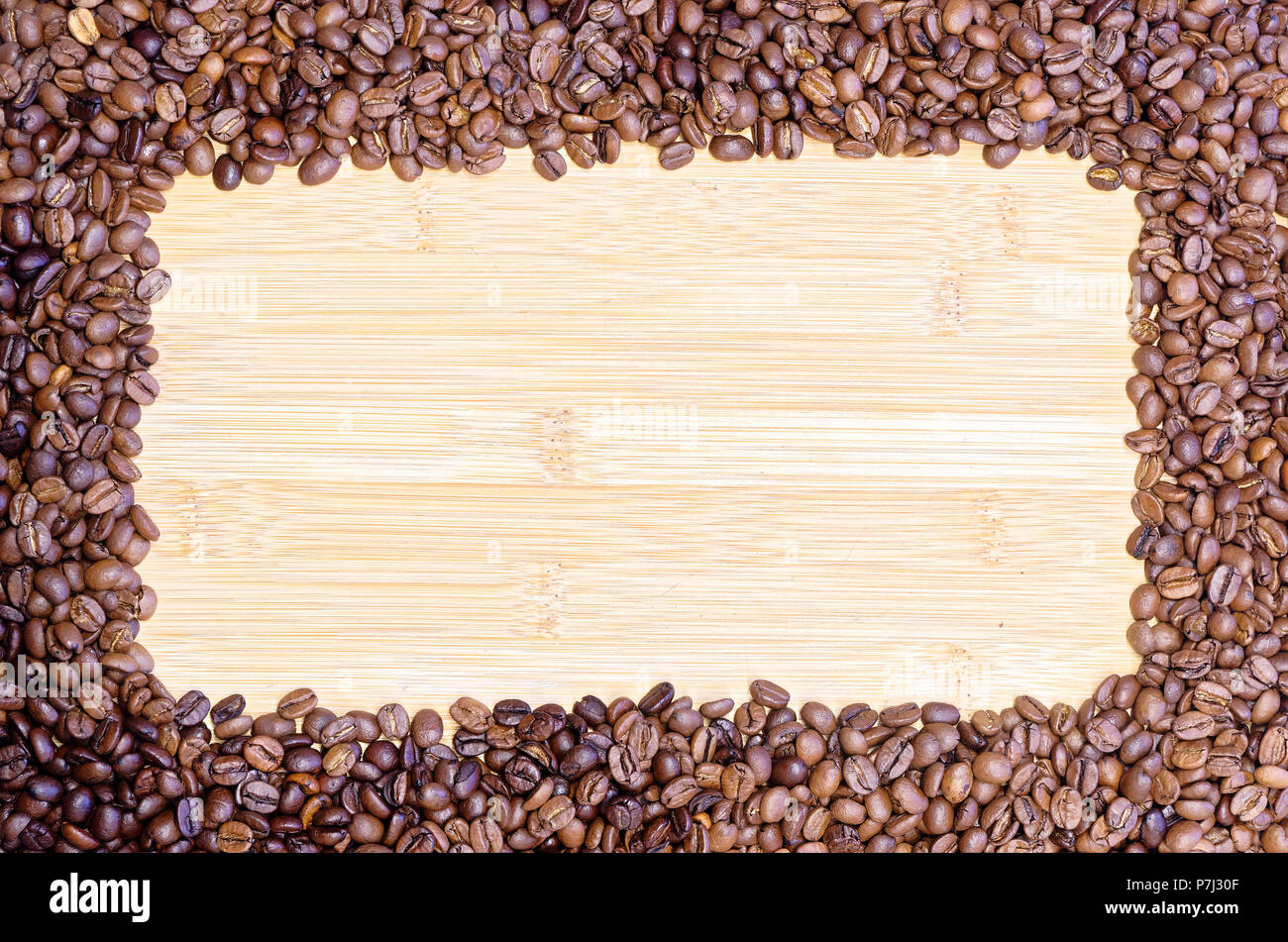 Les grains de café torréfiés allongé sur la planche de bois avec place pour texte personnel Banque D'Images