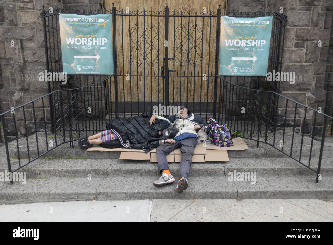 L'homme et la femme à dormir tôt le matin devant une église baptiste le long de la 7e Avenue à Park Slope, Brooklyn New York. Banque D'Images