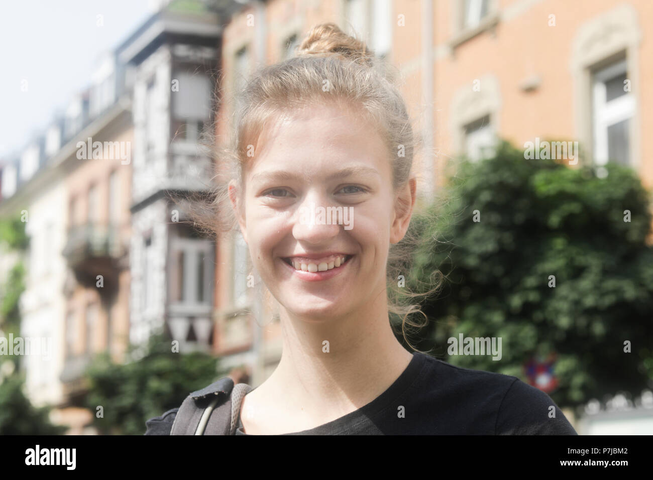 Portrait of a smiling woman standing dans la rue Banque D'Images