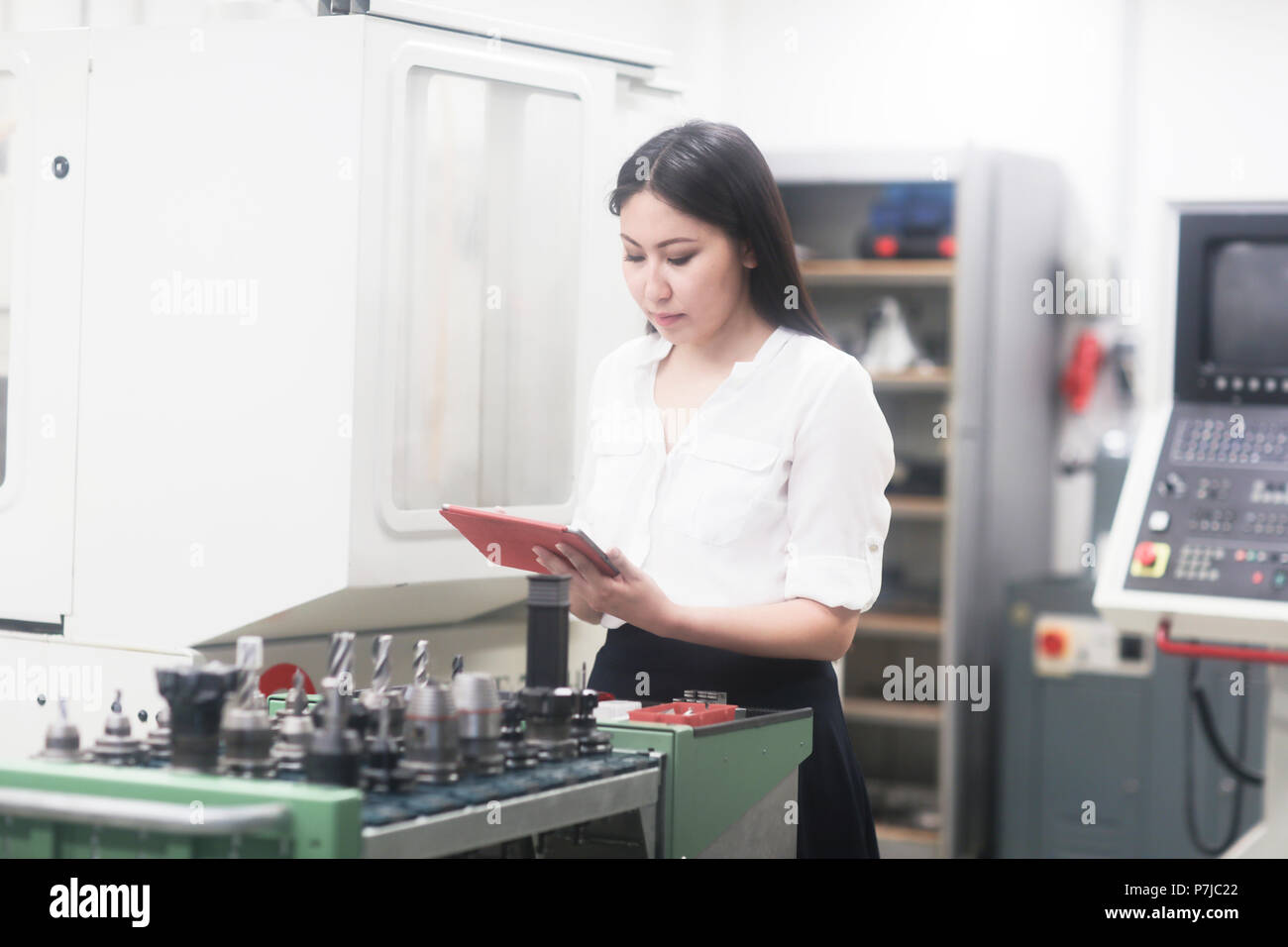 Portrait d'une femme dans un atelier permanent ingénieur tenant une tablette numérique Banque D'Images