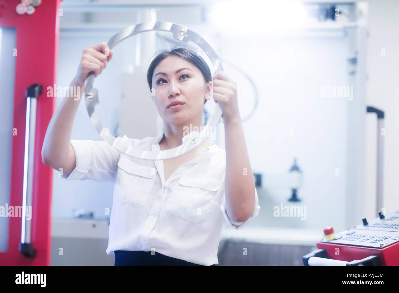 Ingénieur femme debout dans un atelier avec une bague métallique Banque D'Images