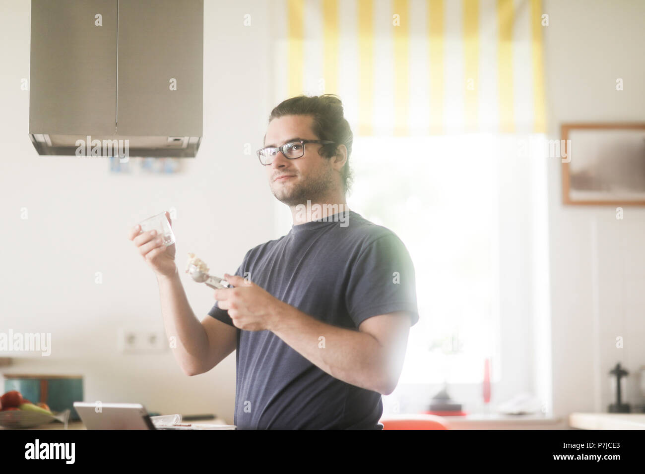 Homme debout dans la cuisine préparer la crème glacée sundae dessert Banque D'Images