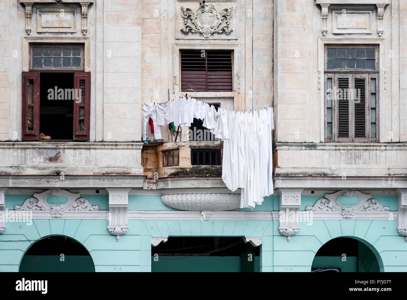 Nettoyer des vêtements blancs, suspendre pour sécher sur une corniche d'un beau bâtiment orné, à La Havane, Cuba. Banque D'Images